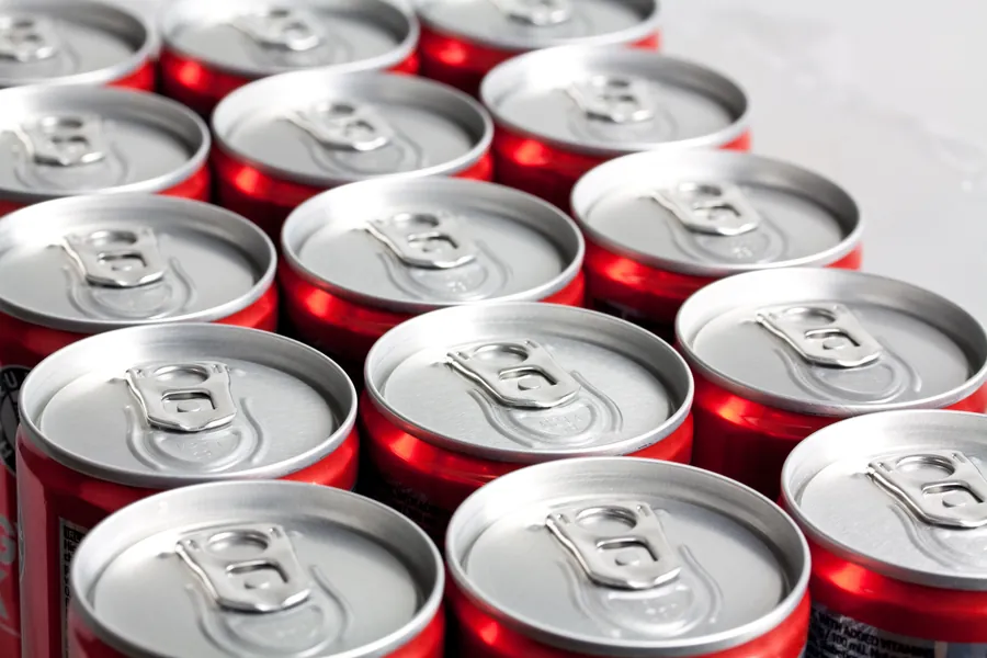 Latas de refresco alineadas listas para distribuir